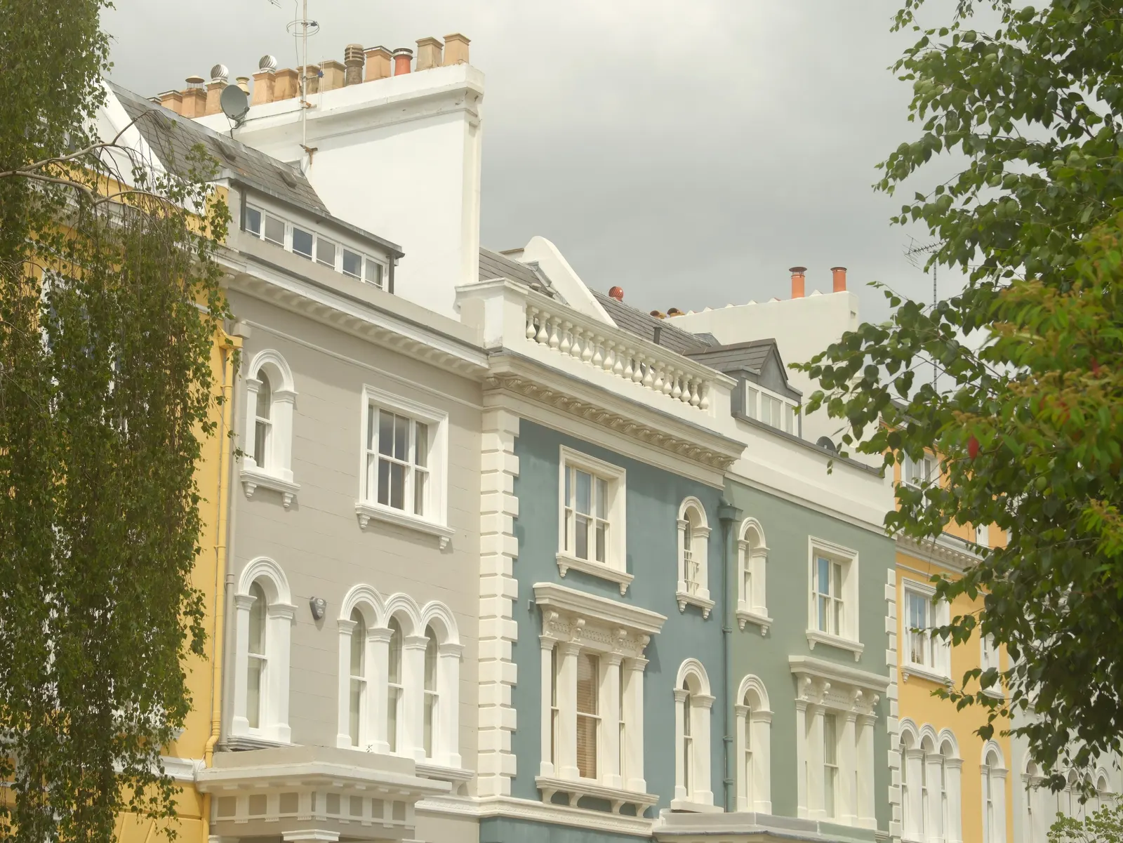 Pastel stucco terrace with a mansard roof storey, the kind of historic frontage a heritage statement describes