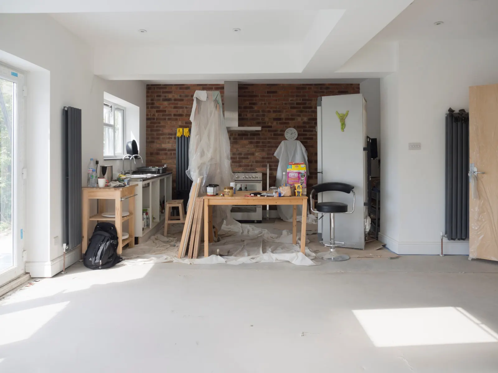Open-plan kitchen extension mid fit-out, with plastered walls and a bare screed floor
